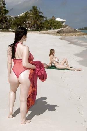 Fervent lesbians stripping nude and playing with dildos on the beach on fansgirls.net