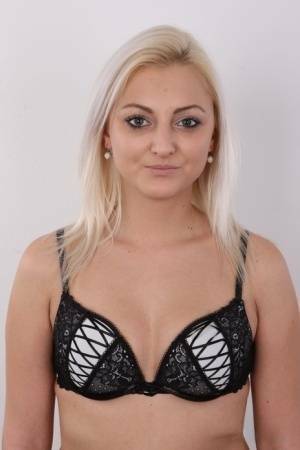 Blonde amateur Sarka stands clothed and then totally naked during solo action on fansgirls.net