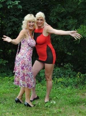 Mature lesbian Dimonty and GF cover their naked bodies in see thru raincoats on fansgirls.net