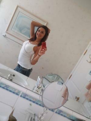 Nasty brunette slut Nikka taking couple of selfies in the bathroom on fansgirls.net