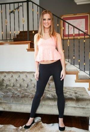 Slim white girl Jillian Janson wears a nice smile while removing spandex pants on fansgirls.net