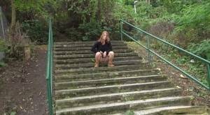 Natural redhead Chrissy Fox squats for a pee on a set of public steps on fansgirls.net