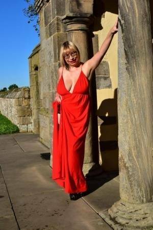 Older blonde Barby Slut doffs a red evening gown to pose nude in hosiery on fansgirls.net