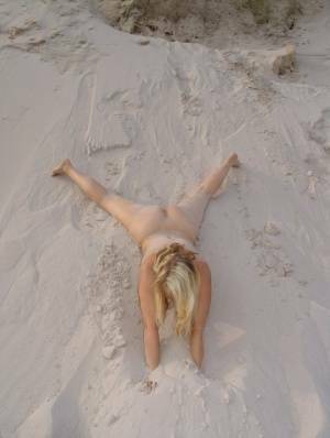 Blonde amateur Sweet Susi gets totally naked on a sandy bank by herself on fansgirls.net