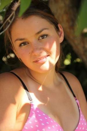 Petite amateur Allie Haze shows her tan lined body in the shade of a tree on fansgirls.net
