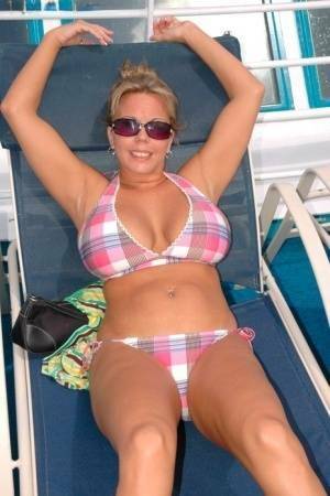 Hugely busty Amber Lynn Bach doffs her bikini to spread her legs wide nude on fansgirls.net