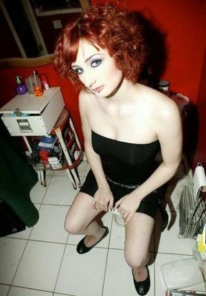 Pale redhead Violet Monroe gets naked in flat shoes while in a bathroom on fansgirls.net