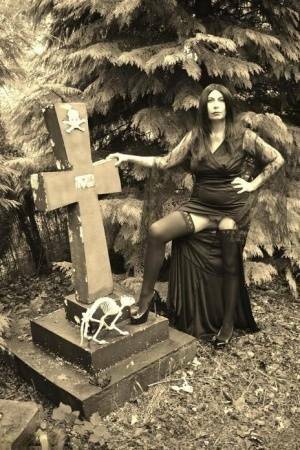 Goth girl Barby Slut bares her big tits and twat atop a casket in the woods on fansgirls.net