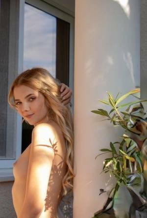 Young blonde Chanel Fenn shows her sexy ass while getting naked in a garden on fansgirls.net