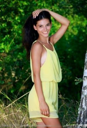 Nice teen Aleksandrina exposes her tan lined body by a hardwood tree on fansgirls.net