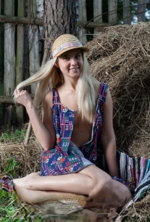 Young blonde Agnes H doffs a dress to get naked on weathered straw in a yard on fansgirls.net