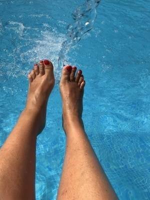 Mature woman Sweet Susi dips her painted toenails into a swimming pool on fansgirls.net