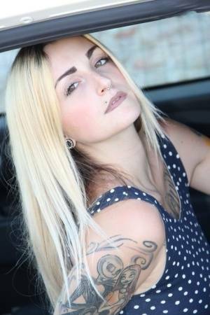 Tattooed girl Medusa Blonde shows her bare feet and ass while in a car on fansgirls.net