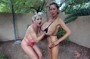 Big titted older women Claudia Marie and Minka kiss outdoors in skimpy bikinis on fansgirls.net
