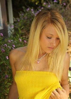 Blonde amateur Teagan bares her A-cup tits in a yard as she gets totally naked on fansgirls.net