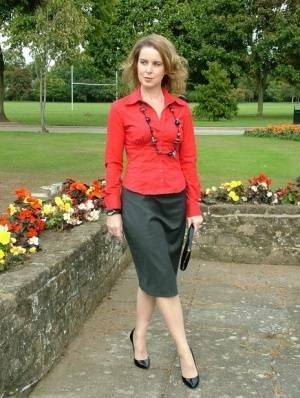 Fully clothed woman steps out of a stiletto heel while visiting a public park on fansgirls.net