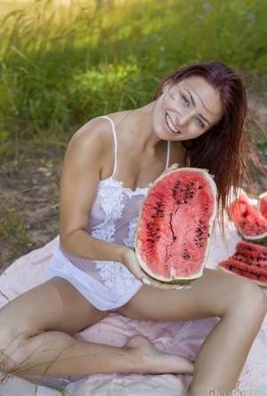 Sweet young girl gets naked while eating a watermelon under a tree on fansgirls.net