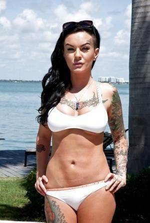 Tattooed whore Lolo Luscious exposing big hooters in swimming pool on fansgirls.net
