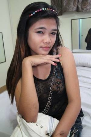 Young Filipina girl with a saucy look stands naked after undressing on fansgirls.net